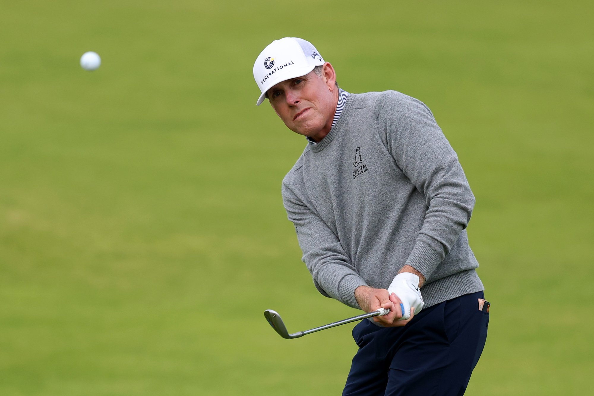 Justin Leonard hitting a chip shot at around head height with wedge