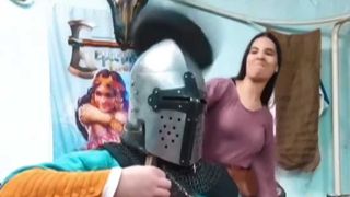 Woman beats man wearing an armoured helmet with a frying pan