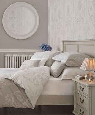 dove grey bed frame with grey printed bed linen, round mirror and bedside table with lamp - Laura Ashley