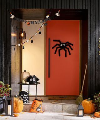 Halloween decorations on a red front door.