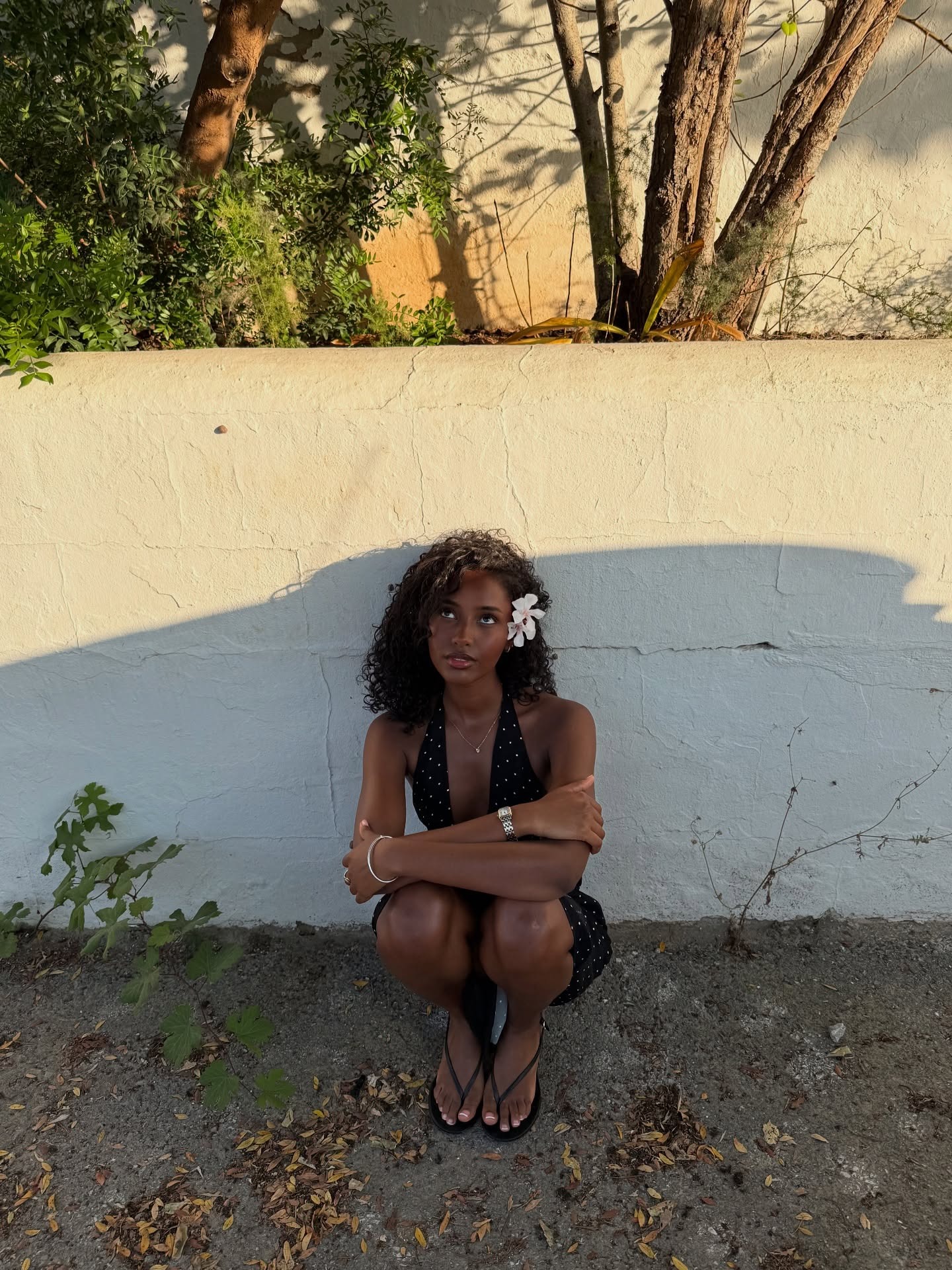 A woman with a side-parted, curly, short hairstyle.