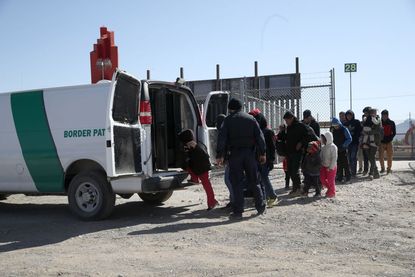 Migrants enter a Border Patrol van.