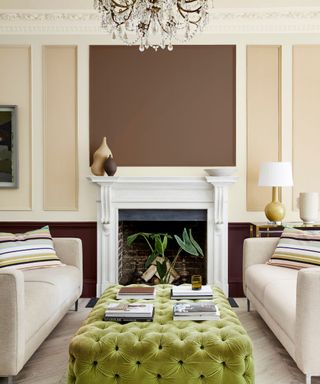 A warm beige living room with two facing sofas and a central fireplace, a caramel brown section has been painted above the fireplace