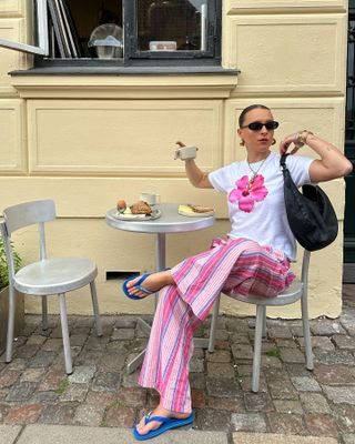 Woman in flower t-shirt and striped pants.