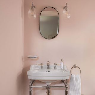 cloakroom with pink walls and white sink