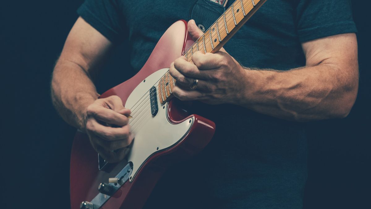 Midsection Of Man Playing Guitar Against Black Background