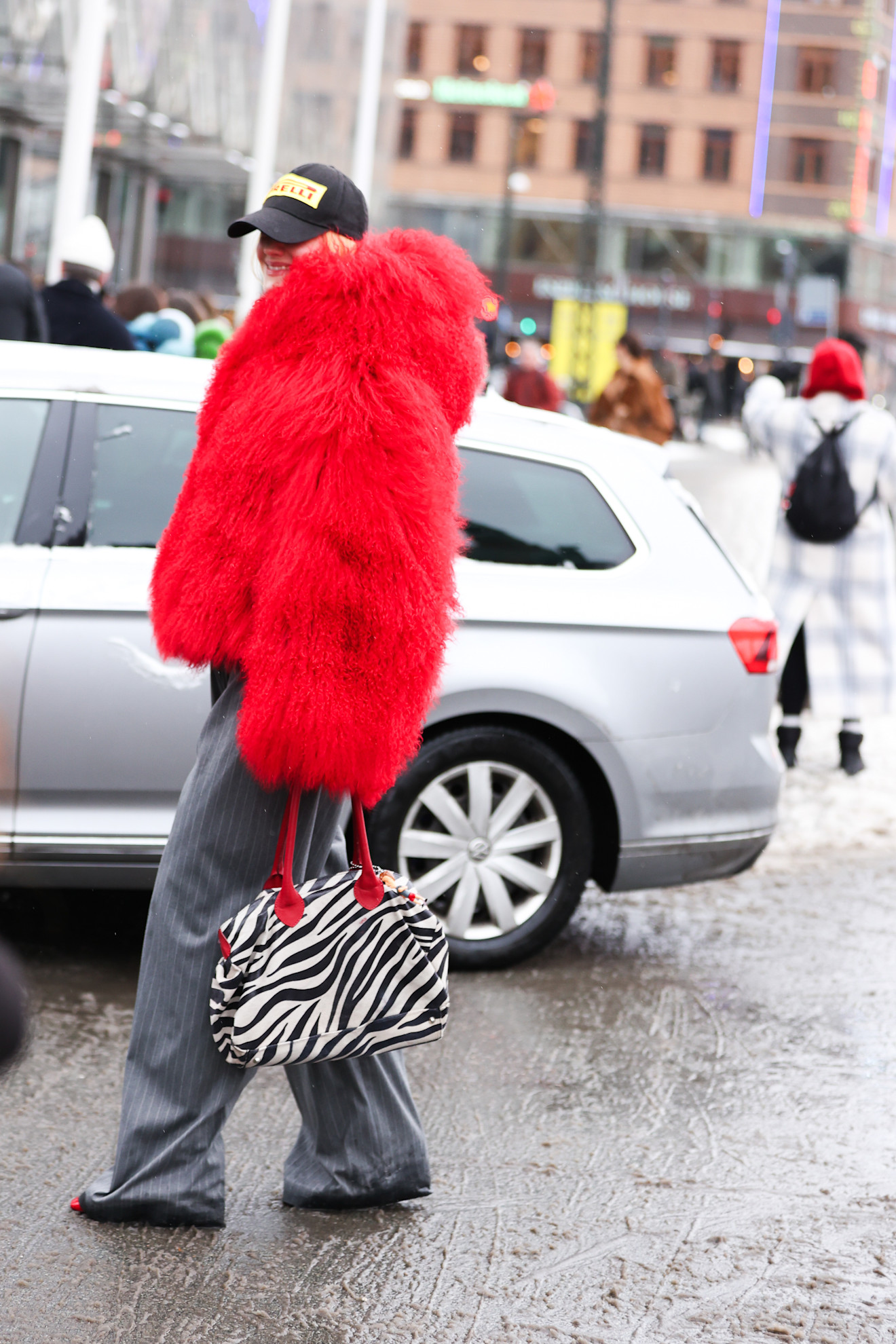a woman wearing a red mongolian coat during copenhagen fashion week