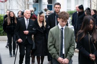 Colin and Sharon arm-in-arm at Dot's funeral procession with the other residents