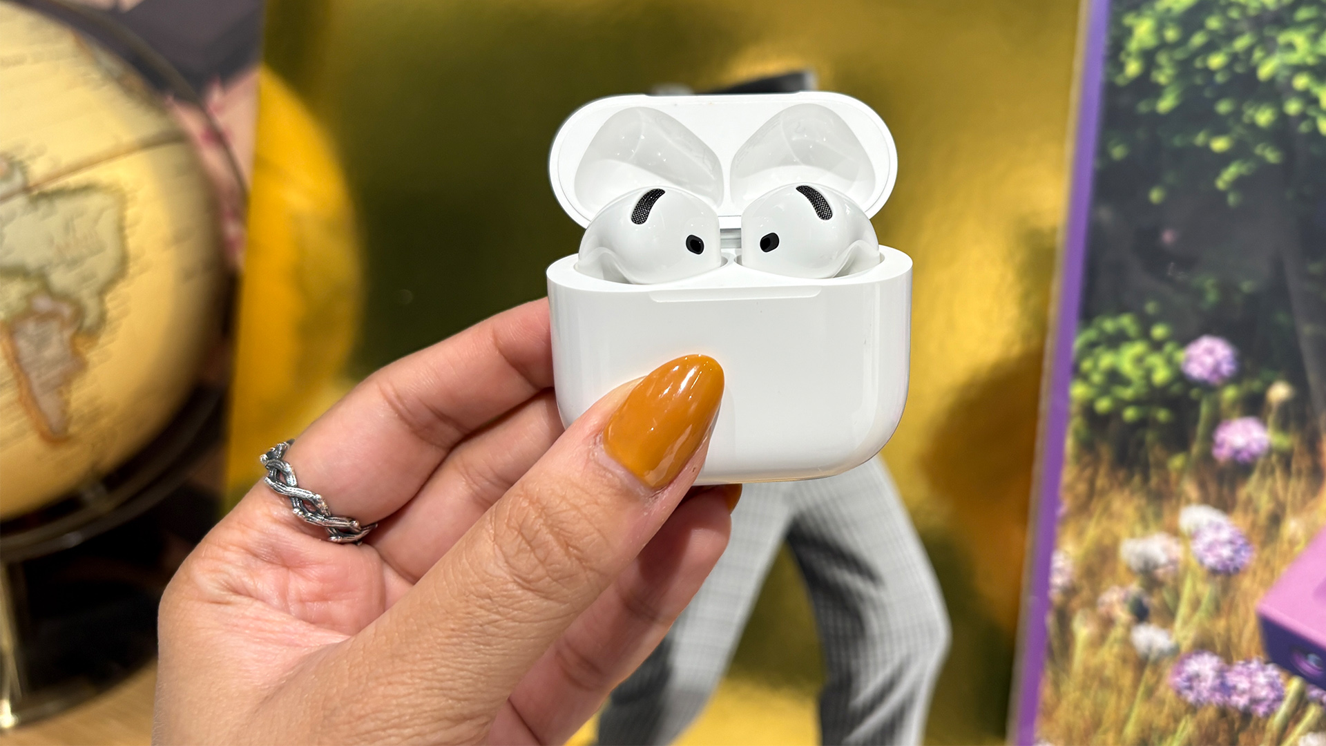 Apple AirPods 5 with Wireless Charging Case in-ear headphones in open case held in hand