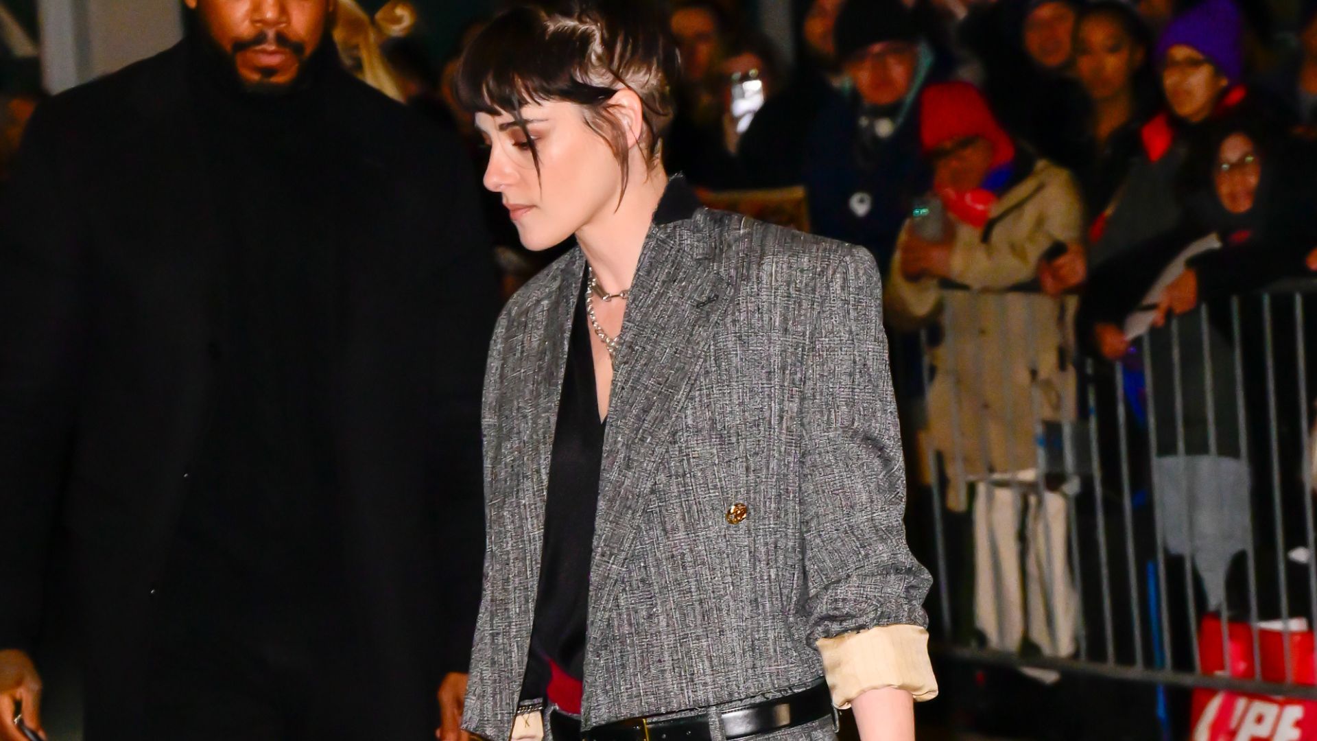 Kristen Stewart wears a grey two piece with red two-tone cone heel shoes.