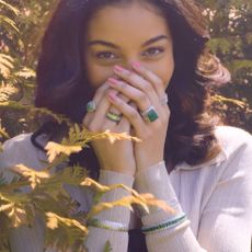 A model wearing a variety of green and silver rings and bracelets from Ross Simons.