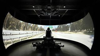 Vector Simulations driving simulator with a massive display making it look like a man is driving the open road.