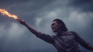 Tom Hiddleston holds flaming sword in Loki