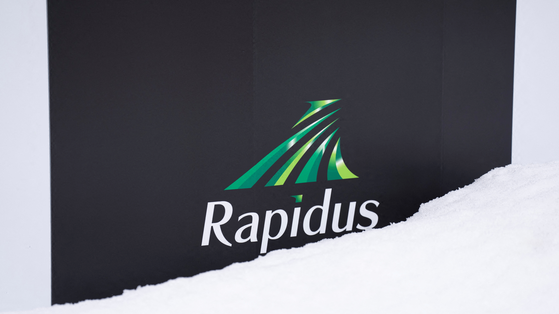 The logo of Rapidus, a Japanese semiconductor manufacturer, covered in snow outside company's semiconductor manufacturing plant 