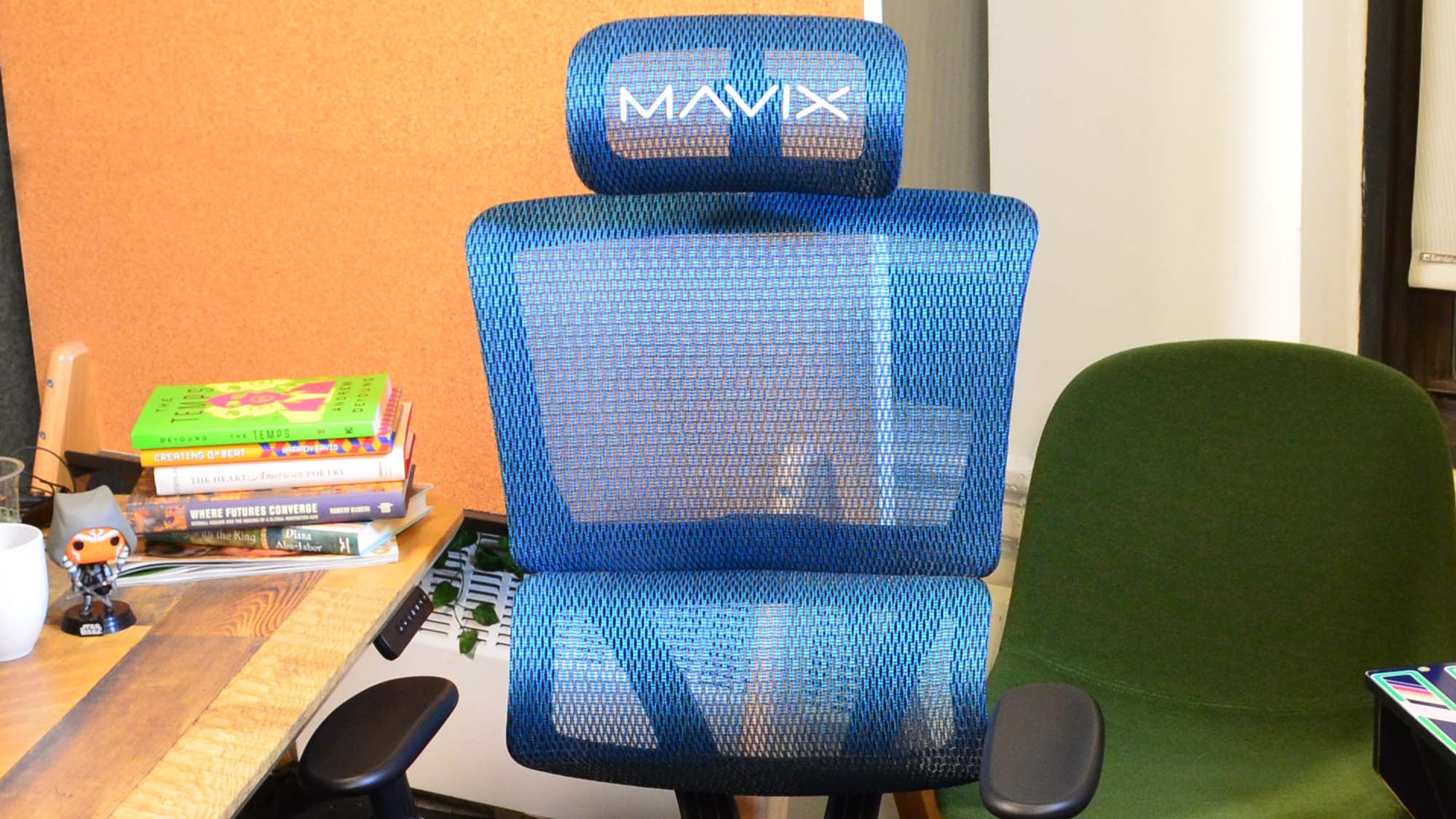 The Mavix M4 in front of a desk with an arcade cabinet in the background