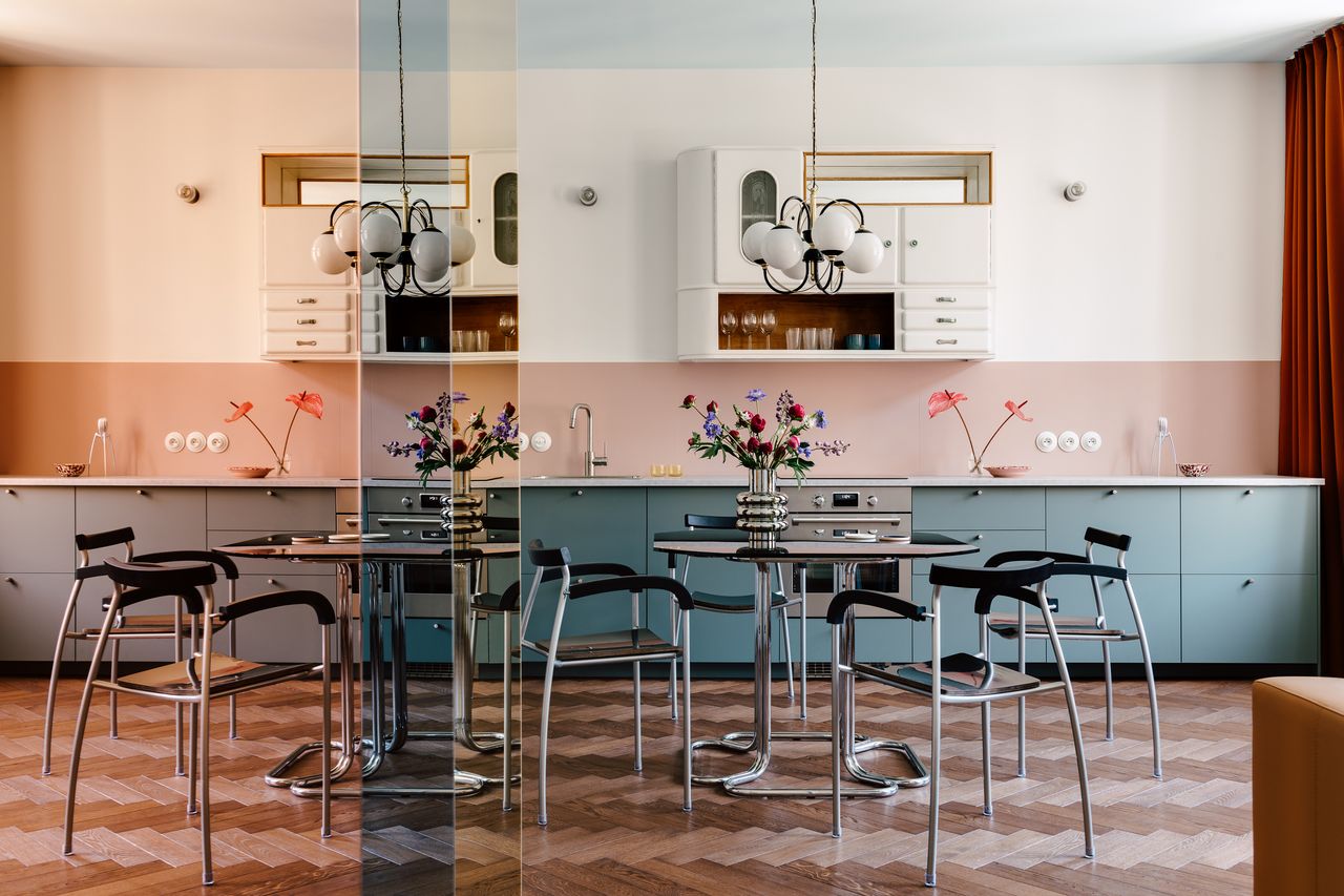 a blue kitchen with a colorful mirror accent