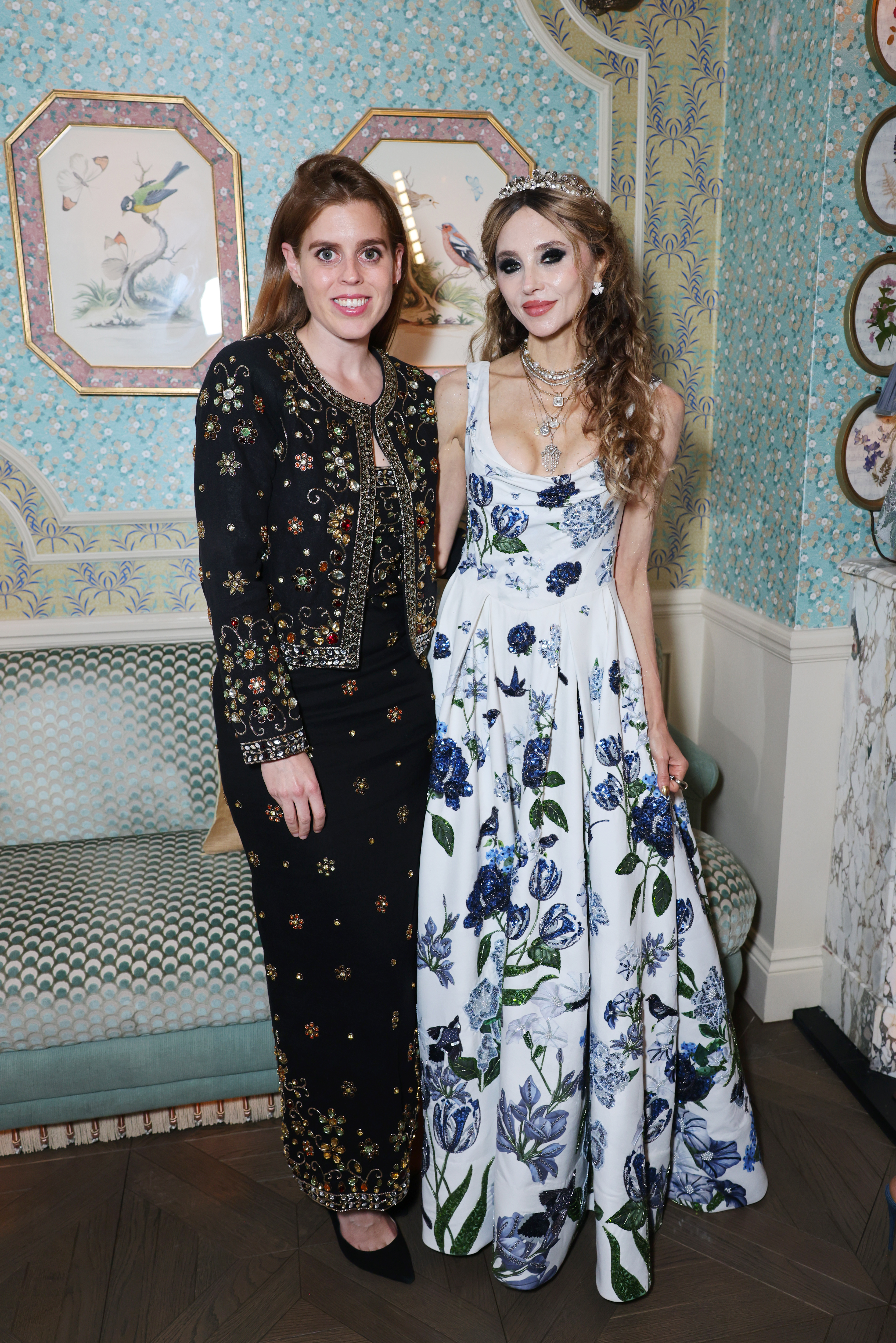 Princess Beatrice and Stacey Bendet posing in front of a blue patterned wall