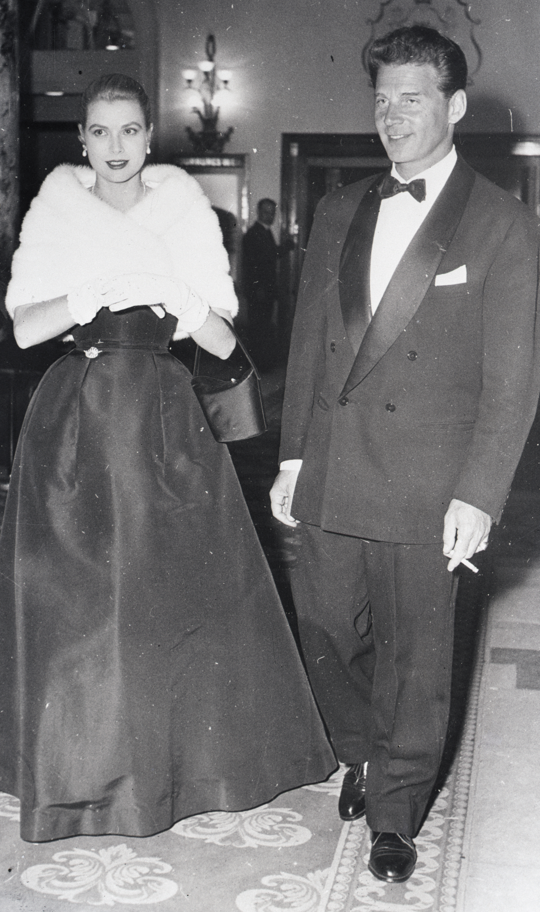 Grace Kelly wearing a fur stole and a long gown at the Cannes Film Festival.