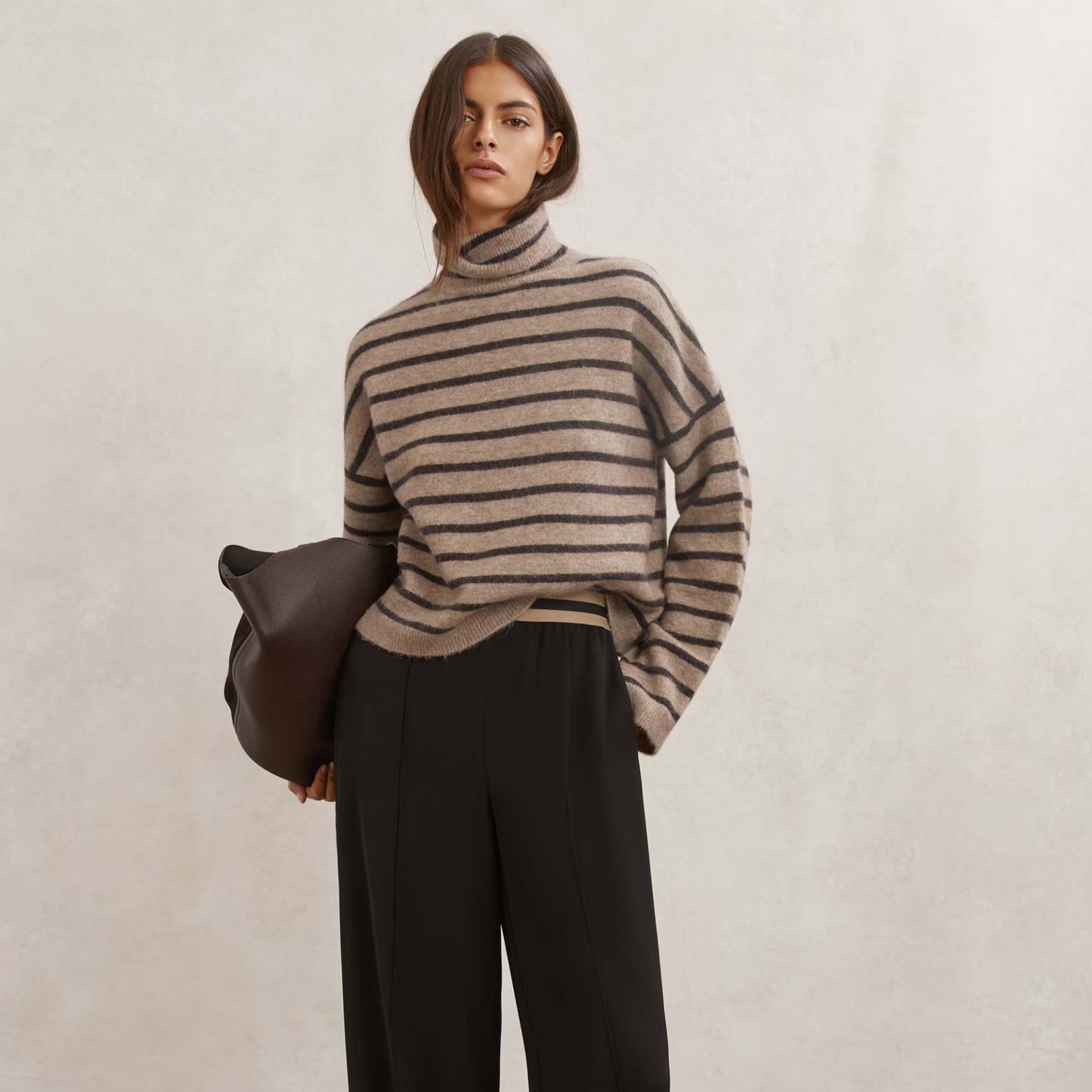 A model wears a brown striped knit from Reiss.