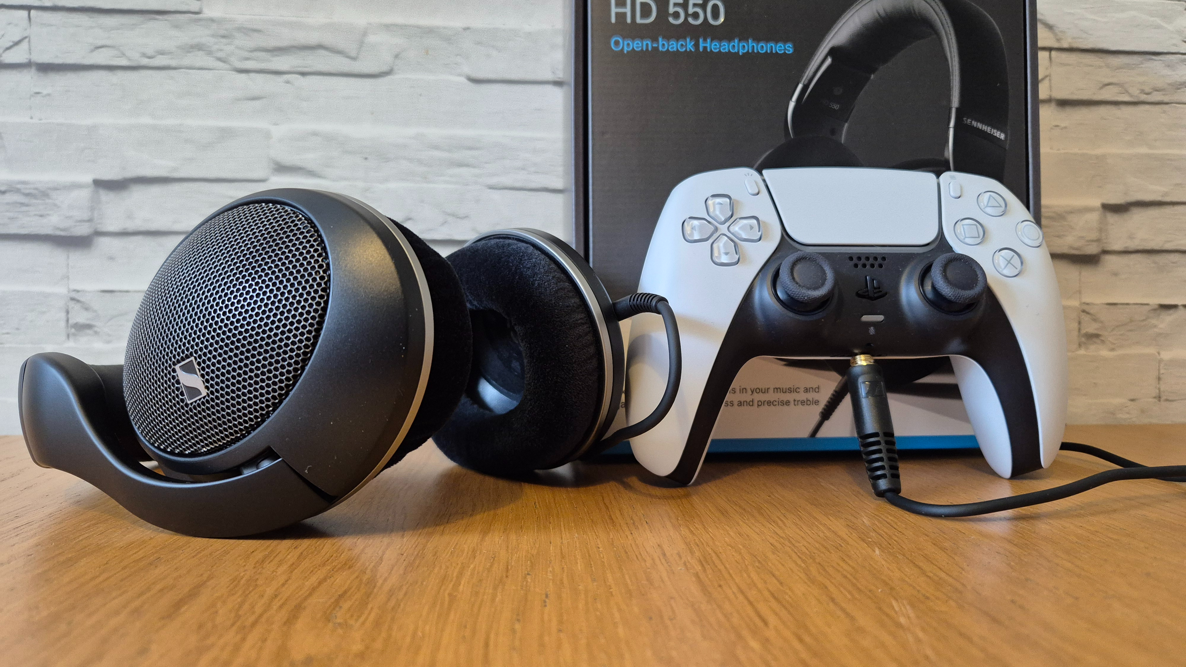 The Sennheiser HD 550 headphones on a wooden surface in front of a white brick background