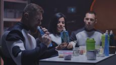a space crew eating food around a table
