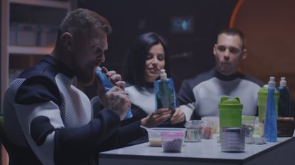 a space crew eating food around a table