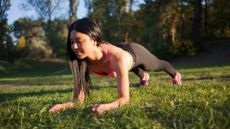 What are core muscles? Image shows young woman doing a plank on the grass in the park