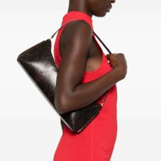 Woman wearing bright red dress and brown Jaquemus Le Calisso shoulder bag. 