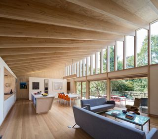 Open plan interior of house with wooden flooring and walls