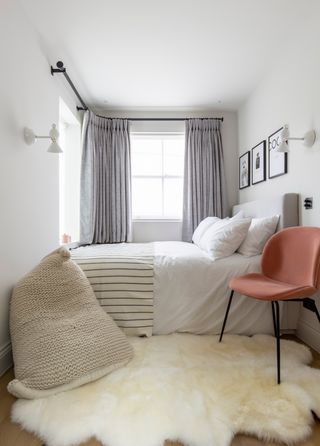 Small cozy bedroom with sheepskin rug and pink velvet chair