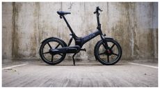 A Gocycle G4i folding electric bike against a concrete background 