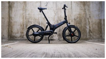 A Gocycle G4i folding electric bike against a concrete background