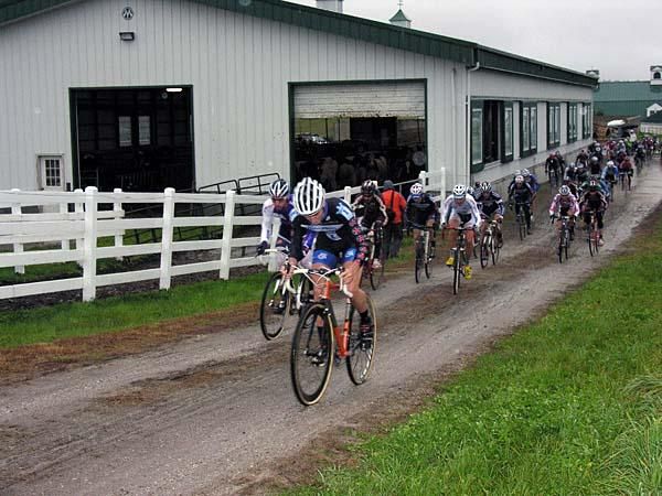 The elite men race past the cow barn.