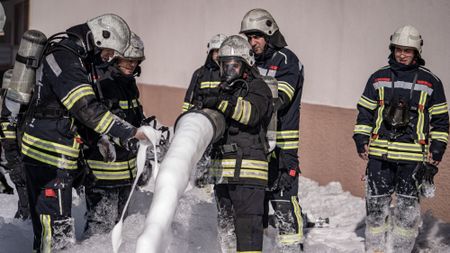 Firefighters deploying fire-suppressing foam