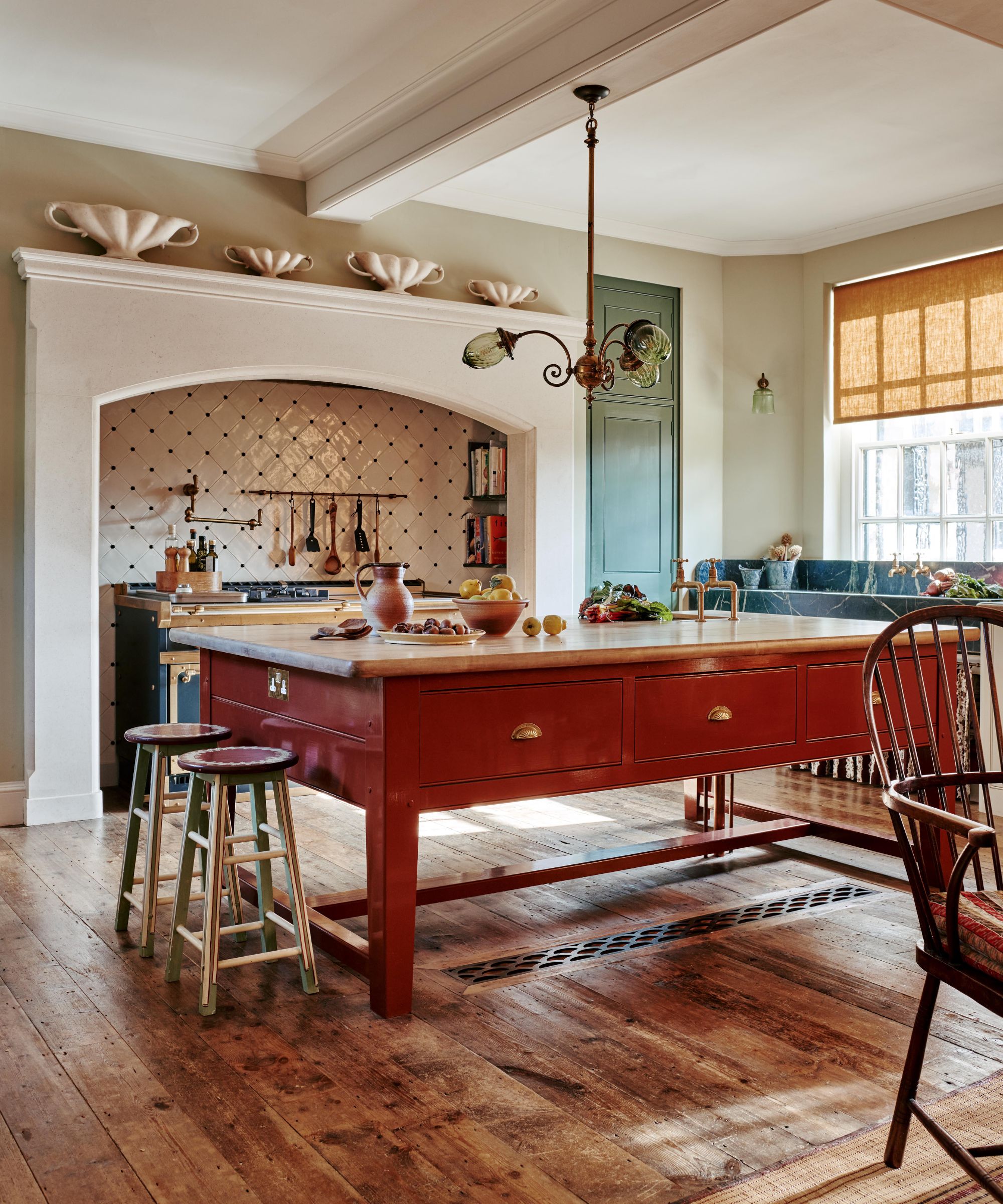 A traditional kitchen with a freestanding terracotta red island