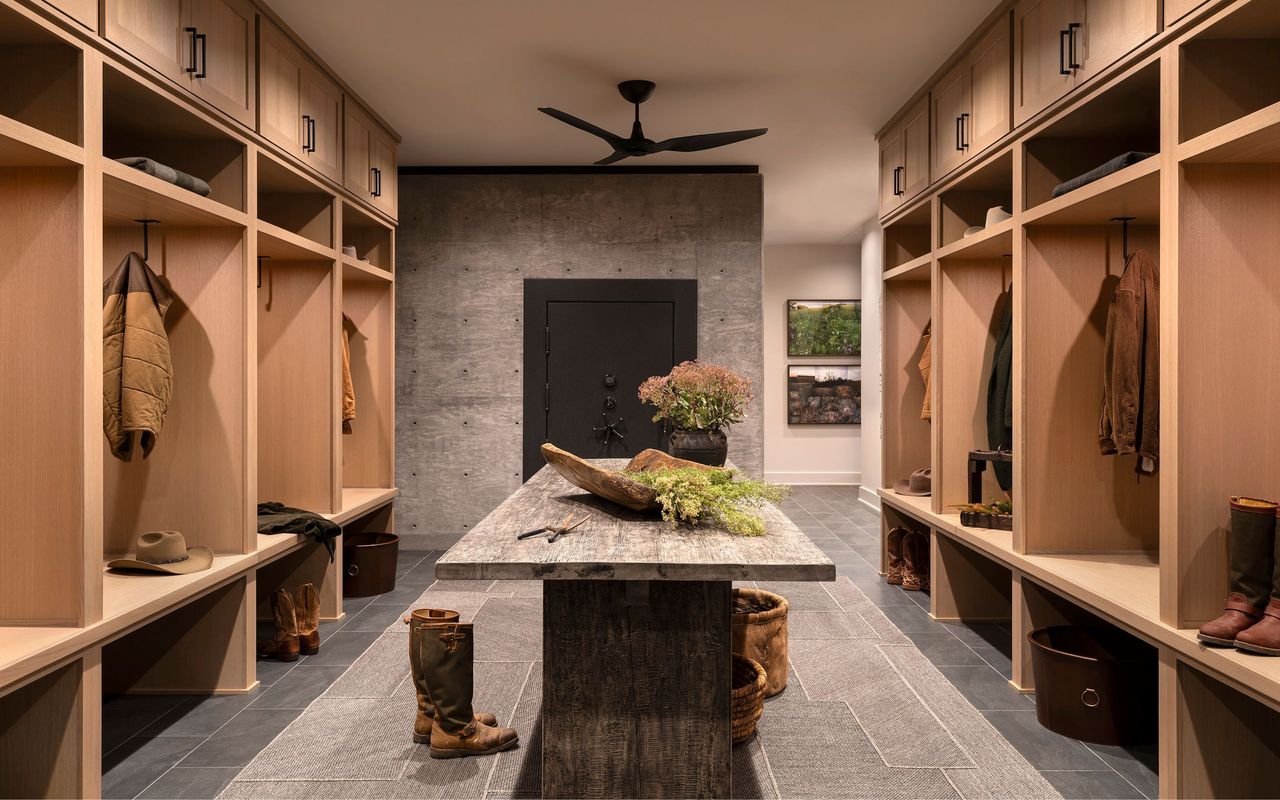 large mud room with wood storage on either side, and wood table in the middle