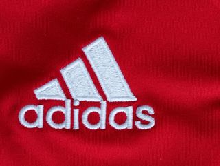 A close-up of the Adidas logo on Ajax&#039;s home shirt, 2012