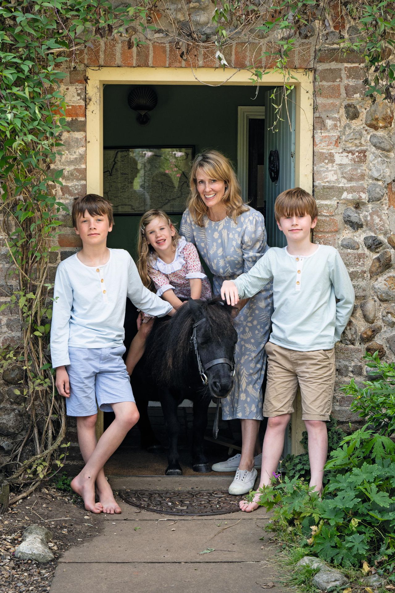 Flora Watkins and her children at home with their Shetland pony, Ollie.