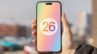 A render of the Apple iOS 26 logo on an iPhone held in a hand.