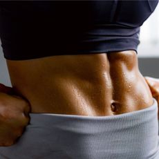 Woman in workout clothes, close up of muscled stomach after trying an In and Out ab method workout