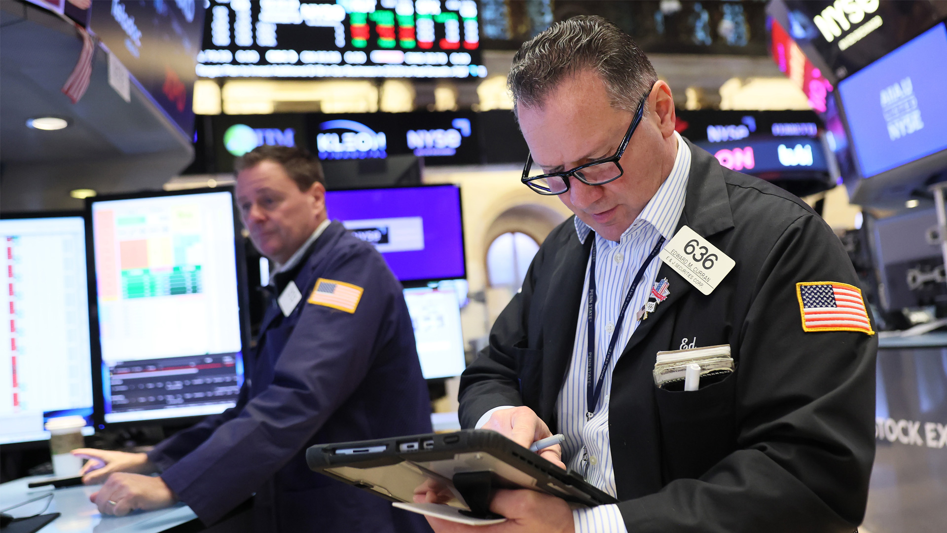 Wallstreet broker looking at a tablet.