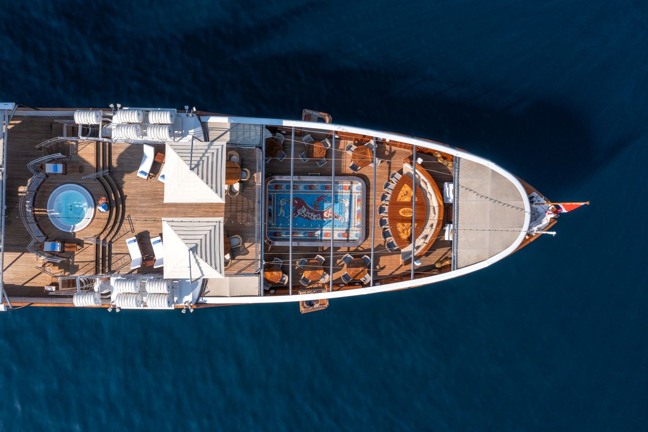 Rear view of the yacht, from above, showing the wooden deck and pool