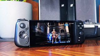 Razer Edge handheld on woodgrain table with Final Fantasy 12 gameplay on screen.