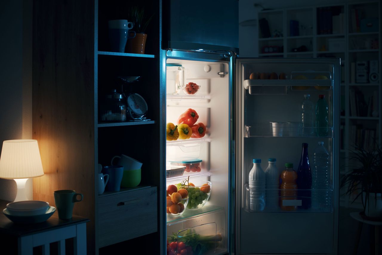 an open fridge at night with a light on