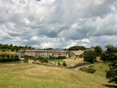 Fig 1: A view of Shilstone House from the south-west, showing the restored home with the farm buildings beyond. The 17th-century gardens extend above and below the house, with a walled garden to the west. One of the ponds is visible below the drive — Shilstone House, Devon. ©Paul Highnam for Country Life