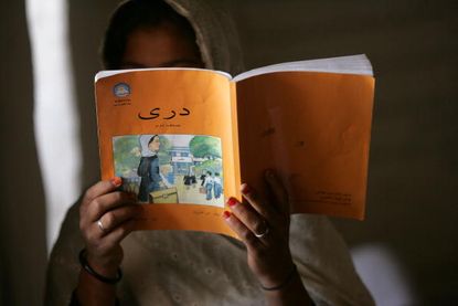 An Afghan schoolgirl reads a book.
