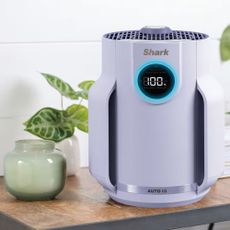 Purple Shark air purifier on a side table next to a candle