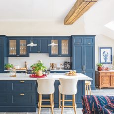 Kitchen with large dining island, cream walls and blue cabinetry