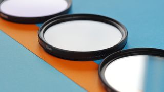 Lens filters laid on an orange and blue paper decorated table