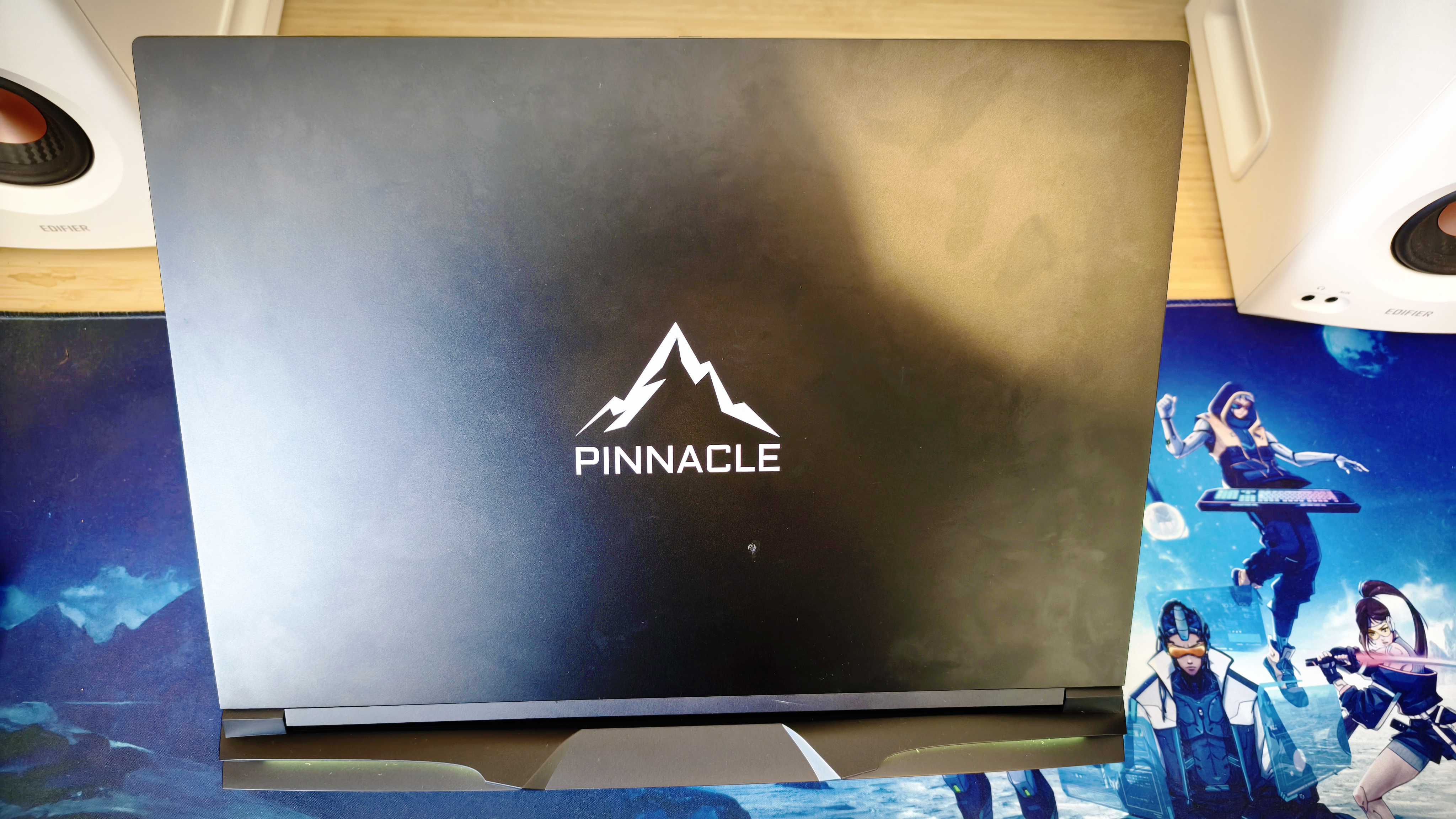 A black Overclockers Pinnacle laptop on a wooden desk
